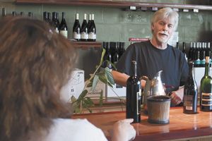 Patrick McElligott talks with a customer at the Oregon Wine Tasting Room near McMinnville, which he managed for 28 years.