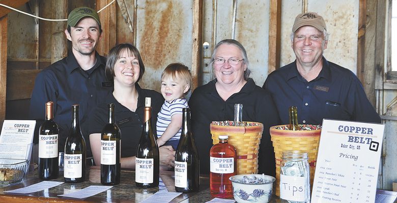 It’s a family affair at Copper Belt, from left: winemaker/founder Travis Cook; his wife, Krista, “veterinarian supporter;” their 2-year-old son, Nathan; his mom, Cathy, who handles the bookkeeping and marketing; and his father, Michael, Travis’ “right-hand man and workhorse of the operation.” ##Photo by Timothy Bishop