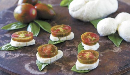 Whether accompanied by DIY cheese or cheese from the market, savor summer on a plate with these super simple Caprese Stacks. Slice vine-ripe plum tomatoes, and stack with slices of mozzarella, fresh basil and a sprinkle of salt. Drizzle with olive oil or balsamic vinegar for a super simple stacked salad Photo by Christine Hyatt