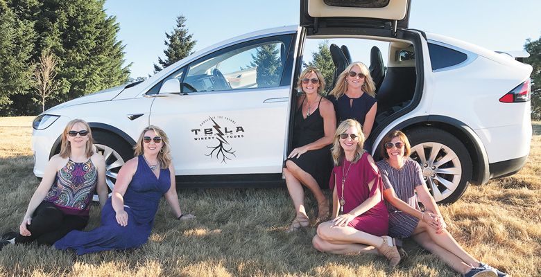 A group of wine-touring friends take a respite near their ride via Tesla Custom Winery Tours. ##Photo courtesy of Tesla Custom Winery Tours