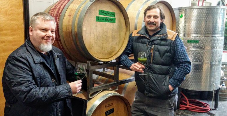 Winemakers Bryum Arnellii and Thomas Monroe salute the latest bottling of moss wine. ##Photo provided