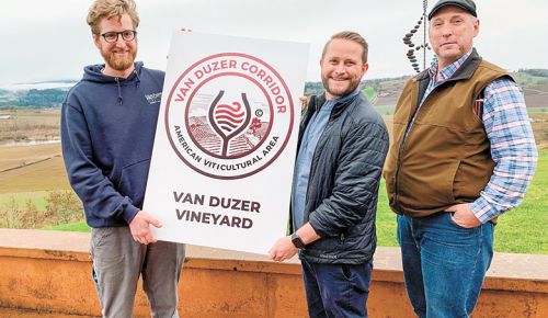 Van Duzer Vineyard staff holding a new sign that AVA member vineyards and wineries will post on their property. From left: Eric Misiewicz, winemaker; Brandon Allen, sales and marketing manager; and Bruce Sonnen, vineyard manager. ##Photo by Patty Mamula