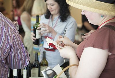A participant at the 2011 Wine Blogger’ Conference in Virginia takes notes after
sampling wine. Attendees also toured area vineyards and wineries. Photo by Daane Studios.