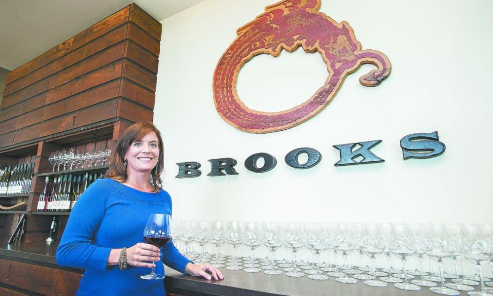 Janie Brooks Heuck has managed Brooks Winery since Jimi’s death in 2004. The winery logo, an Ouroboros, is a mythical dragon symbolizing re-creation, which her brother wore as a tattoo. ##Photo by Marcus Larson