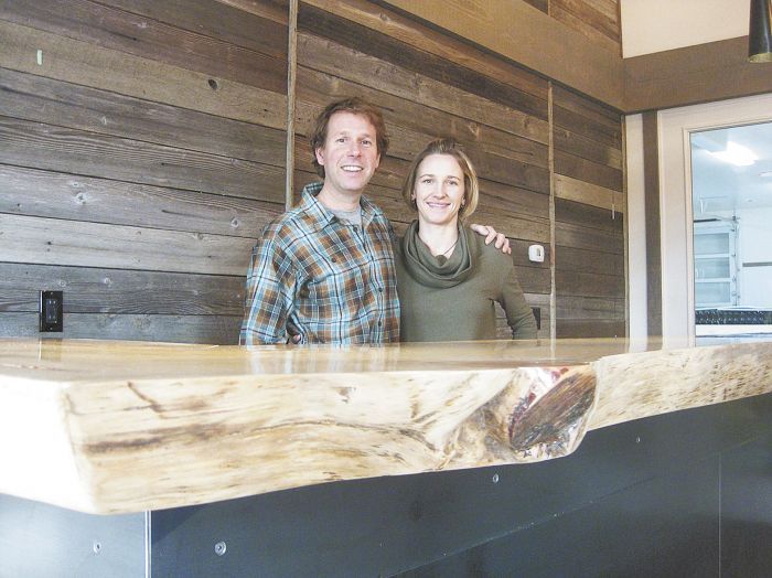 Steve Thompson and his wife, Kris Fade, behind the 100-year-old Ponderosa pine slab that anchors the interior of their tasting room featuring Analemma Wines.