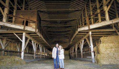 Sanjeev Lahoti and Angela Summers stand inside the huge dairy barn, which has now been dismantled for reuse in their new tasting room.