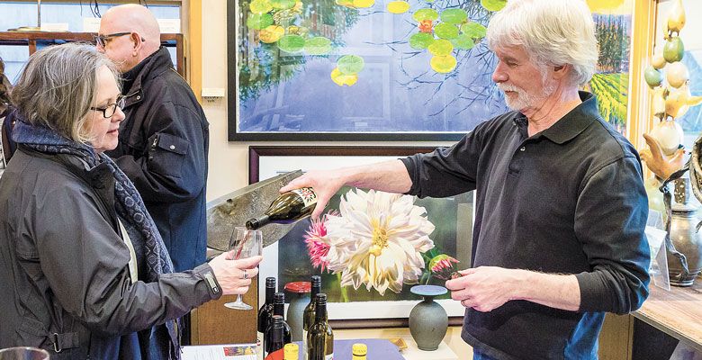 Patrick McElligott offers samples of Sineann Wine at the Northwest by Northwest Gallery during the Wine Walk. ##Photo by Chris Bidleman