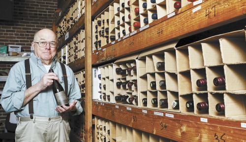 Nick chooses a wine inside the restaurant’s wine cellar, a collection he started 40 years ago. ##Photo by Rockne Roll