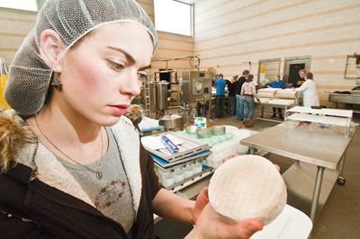 An OSU student checks on artisan cheese she made at the school’s Arbuthnot Dairy Center in Corvallis. Photo by Lynn Ketchum.