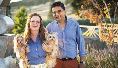 Saffron Fields Vineyard owners Angela Summers and Sanjeev Lahoti outside the tasting room. Summers holds their flower children; Yorkshire terriers Daisy (left) and Iris. ##Photo by Andrea Johnson