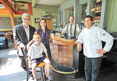 From left, restaurant owners Matthew and Katherine Otten with their son, Liam, bartender Chris Churilla and Executive Chef
Hamid Serdani, pose at the bar of the newly opened Terminus. Photo by Ethan Erickson of the Corvallis Gazette-Times.