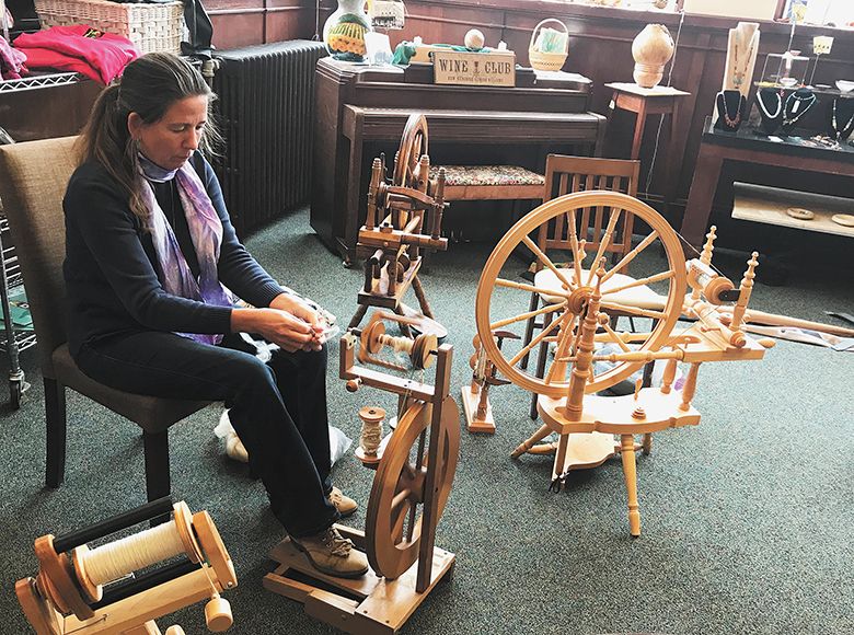 A woman sitting at a spinning wheel in Triple Oak Wine Vault’s “sip and spin” group. ##Photo by Betty Tamm