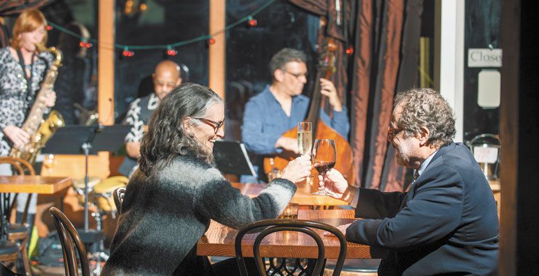 A couple toasts the evening while enjoying the Portland-based “new jazz” trio. ##Photo by Kathryn Elsesser.