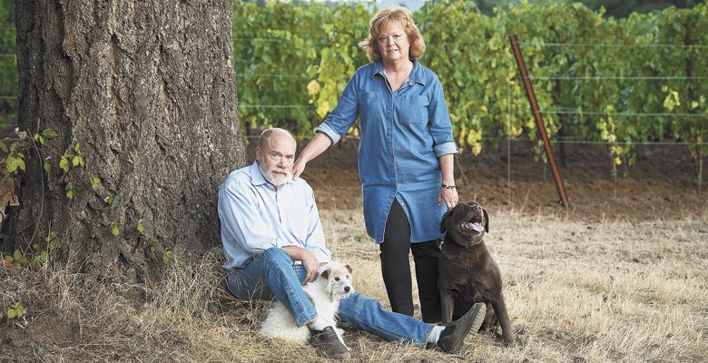 Celia and Ken Austin at Rain Dance Vineyards in the Chehalem Mountains count on the partnership of Emerson, a chocolate Lab, and Bella, a Jack Russell terrier, to manage the property. ##Photo by Andrea Johnson