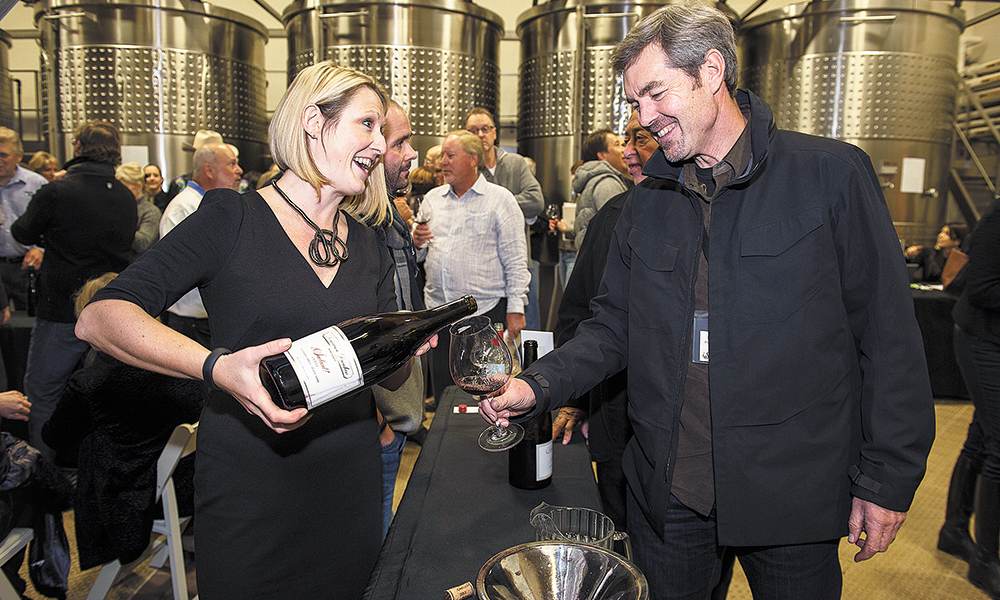 Ashley Bell of Domaine Drouhin Oregon pours a 2013 Pinot Noir for Ron Penner-Ash during the Big Board Auction held annually at Domaine Drouhin outside Dayton. ##Photo by Andrea Johnson