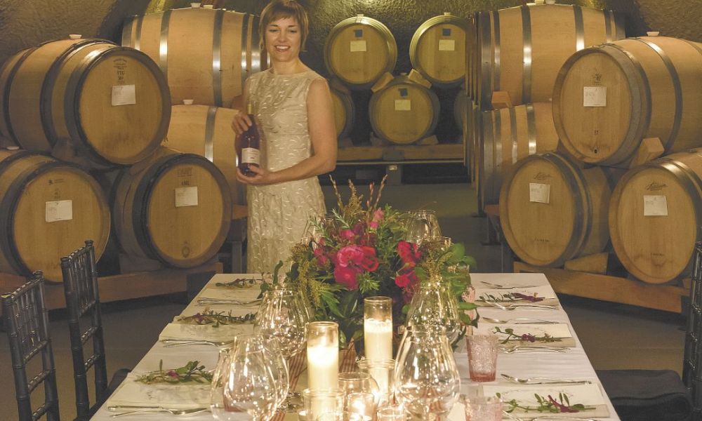 Andrea Carpenter readies the table for a special dinner titled “LOVE” hosted inside Archery Summit’s barrel caves. The feast featured chocolate in every course with wine pairings from the winery.##Photo by Andrea Johnson