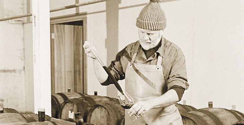 David checks on Pinot Noir in barrel during the vintage of 1983.##Photo by Tom Ballard