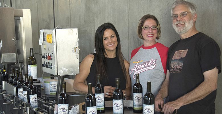 Higgins and Hubatch join Tom Schaad, who donated his bottling line, for the bottling and labeling of the memorial wine at August Cellars in Newberg on June 5.##Photo by Andrea Johnson