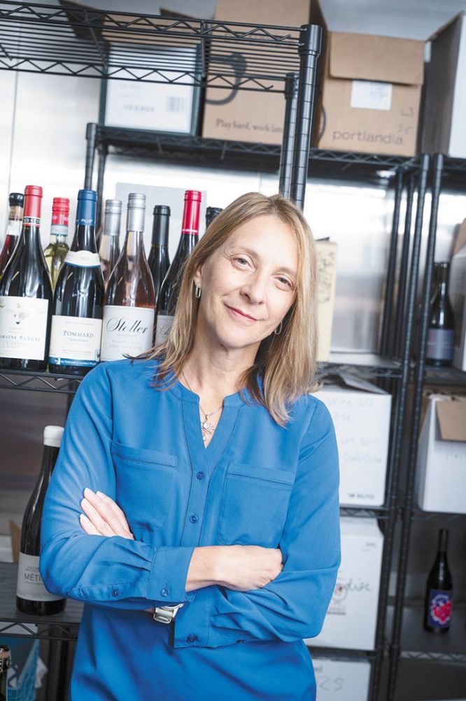 Toni Ketrenos with racks of Oregon wine. ## Photo by F. Miller Photography