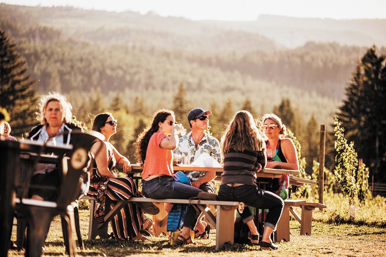 Guests relaxing at one of the picnic tables while enjoying the wines and views at Grateful Vineyard.##Photo by Pickles Photography