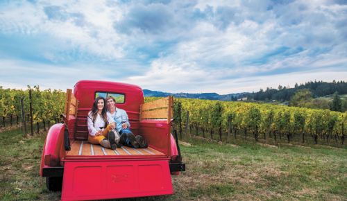 Anacréon Winery owners, Danell and Kipp Myers, enjoy time in their Chehalem Mountains estate vineyard.  Their red 1947 Ford pickup is the winery mascot, perfect for photos and enjoyed by visiting guests. ##Photo BY CAROLYN WELLS KRAMER