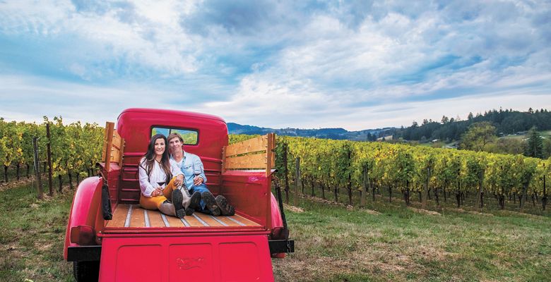 Anacréon Winery owners, Danell and Kipp Myers, enjoy time in their Chehalem Mountains estate vineyard.  Their red 1947 Ford pickup is the winery mascot, perfect for photos and enjoyed by visiting guests. ##Photo BY CAROLYN WELLS KRAMER