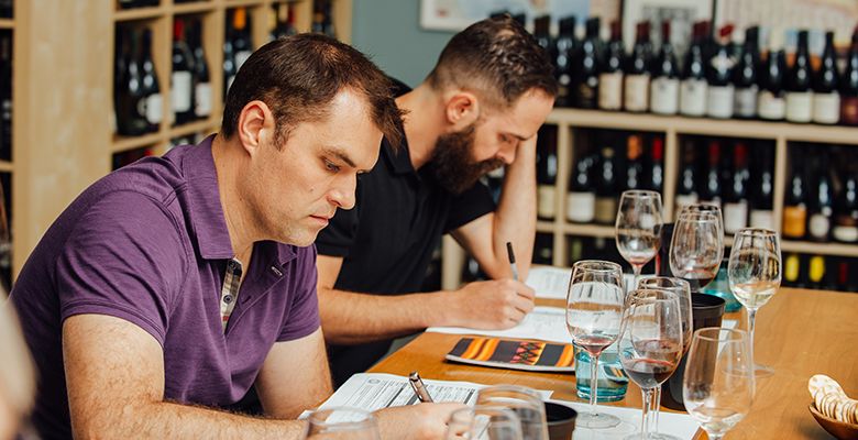 Students Kevin Franck (left) and Sean Curtin study a handout during class at The Wine & Spirit Archive (WSA).