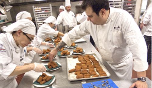Host chef Rocky Maselli (right) prepares pheasant and ham croquettes with fired Oregon black truffle at last year’s Grand Dinner with help from the staff from the Lane Community College Culinary Institute. Photo by David Barajas.