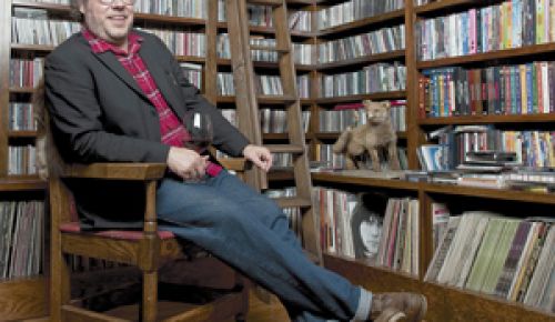 Matt Brown of Bladen County Records relaxes with a glass of wine in front of a massive CD collection belonging to his roommate, Issac Brock of Modest Mouse.