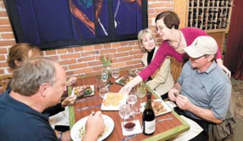 Olive You patrons Rick and Roxanne Robinson (left), and Ed and Jeanne DeRaeve are served by the restaurant’s co-owner Marilyn Turner.