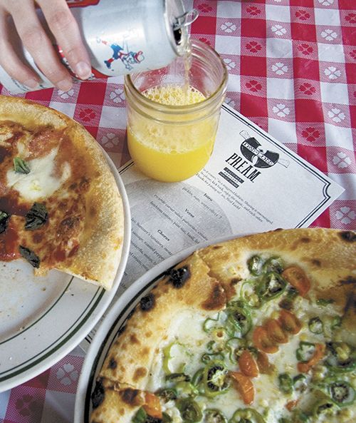 Get funky with an OG Brass Monkey (Old German lager beer and orange juice) on Monday nights at Ned Ludd in Portland. Not only do the cooks serve up a soundtrack of old school rap and hip hop, but also wood-fired pizzas. Shown above are a classic Margherita and the special of the night featuring corn, Sun Gold tomatoes and Padrón peppers on a smoked cream base. ##Photo by Peter Syzmczak