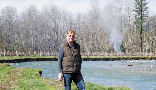 Bridgeview s Rene Eichmann stands on the eroding bank of Sucker Creek, where his vines flourished until the creek changed course this winter. ##Photo by Maureen Flanagan Battistella
