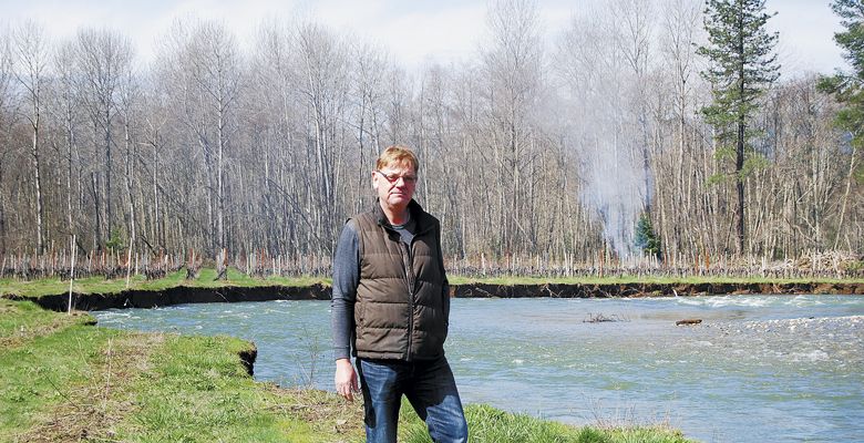 Bridgeview s Rene Eichmann stands on the eroding bank of Sucker Creek, where his vines flourished until the creek changed course this winter. ##Photo by Maureen Flanagan Battistella