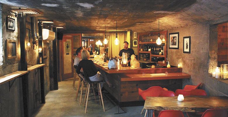 Co-owner Jeff Vejr chats with patrons in Les Caves’ subterranean bar. ##Photo by Mark Stock