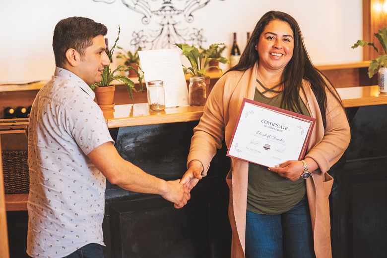 AHIVOY graduate Elizabeth Sanchez as she accepts her graduation certificate. ##Photo by Sean Carr Photography