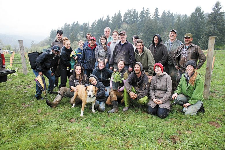 Jessica Applegate (holding plant) with
friends, family and some members of the
“vine punk” crew at Applegate House
Vineyards on planting day, April 5, 2014. ##Photo provided