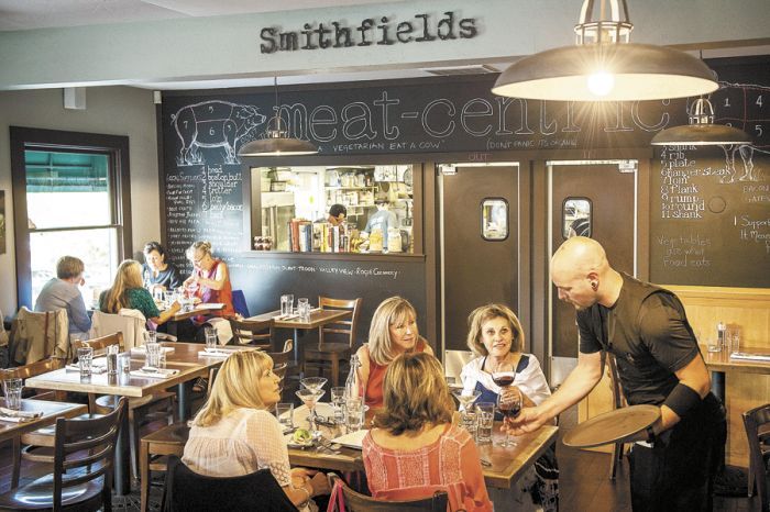 A waiter delivers a glass of wine to a table at Smithfields in Ashland. Photo by Andrea Johnson. A waiter delivers a glass of wine to a table at Smithfields in Ashland. Photo by Andrea Johnson.