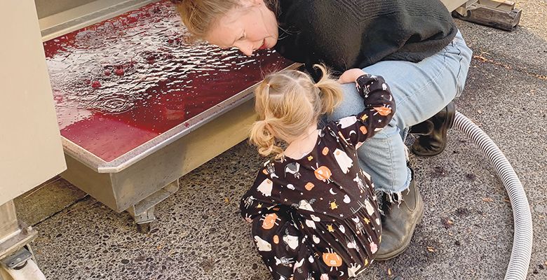 Kelsey Albro Itämeri, itä Wines’ owner and winemaker, 
sharing a harvest moment with her young daughter. ## Photo provided by itä Wines