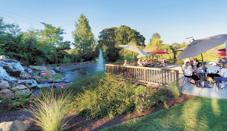 Guests relax with wine and food on Aurora Colony Vineyards’ expansive deck. ##Photo provided