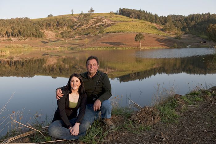 Founder Moe Momtazi and daughter Tahmiene, who oversees winemaking at Maysara Winery, pose in front of a manmade reservoir on the winery’s large estate. Founder Moe Momtazi and daughter Tahmiene, who oversees winemaking at Maysara Winery, pose in front of a manmade reservoir on the winery’s large estate.