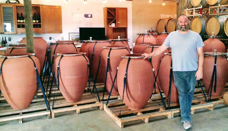 Inside his studio/winery outside Sherwood, winemaker and professional potter Andrew Beckham stands among his amphorae, clays vessels for fermentation. ##Photo by Michael Alberty