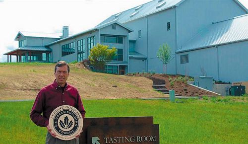 Bill Stoller holding the LEED Gold Certification plaque for the winery building behind him. ## Photo provided by Stoller Wine Group