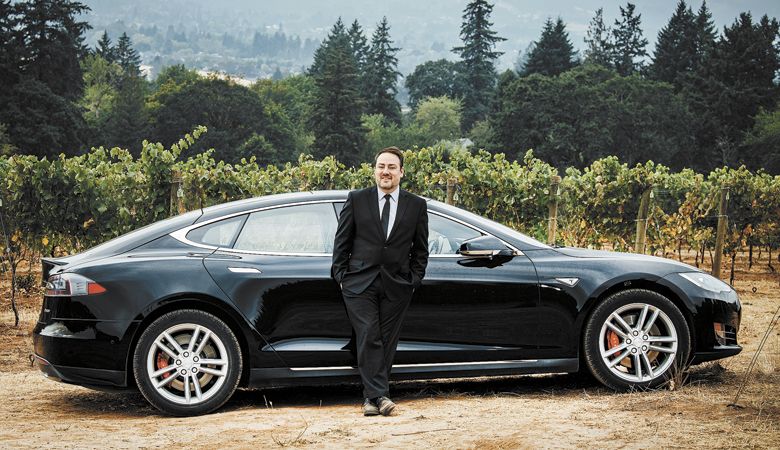 Black Tie Tours owner Stefan Czarnecki waits for guests at Bells Up Winery in Newberg. The Tesla is one of many vehicles available for visitors. ##Photo by Kathryn Elsesser