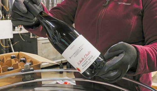 A person handling a Revino wine bottle as it exits the Willamette Valley Vineyards bottling line. ## Photo provided by Willamette Valley Vineyards