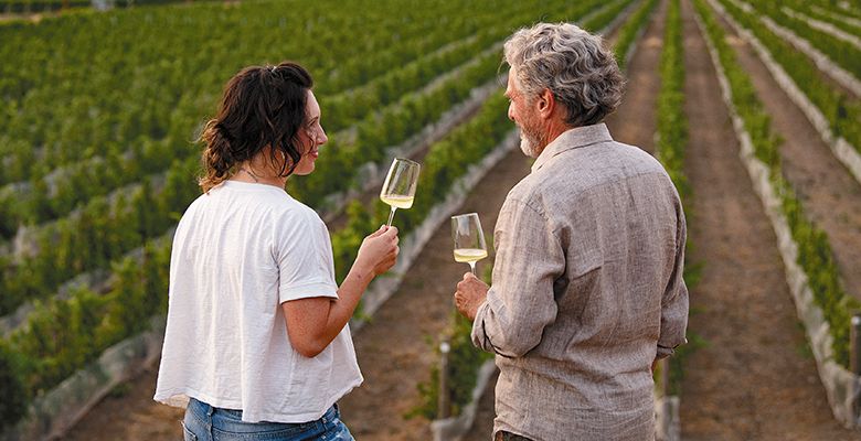 Brooke Delmas Robertson standing in family-owned SJR Vineyard with father Steve Robertson. ## Photo provided by Delmas