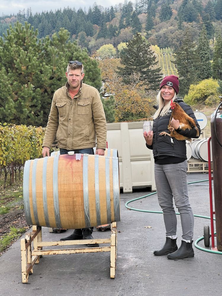 Co-owner and winemaker Bryan Laing with intern Becky Boyd holding Feathers the chicken. ##Photo by Sarah Murdoch Co-owner and winemaker Bryan Laing with intern Becky Boyd holding Feathers the chicken. ##Photo by Sarah Murdoch