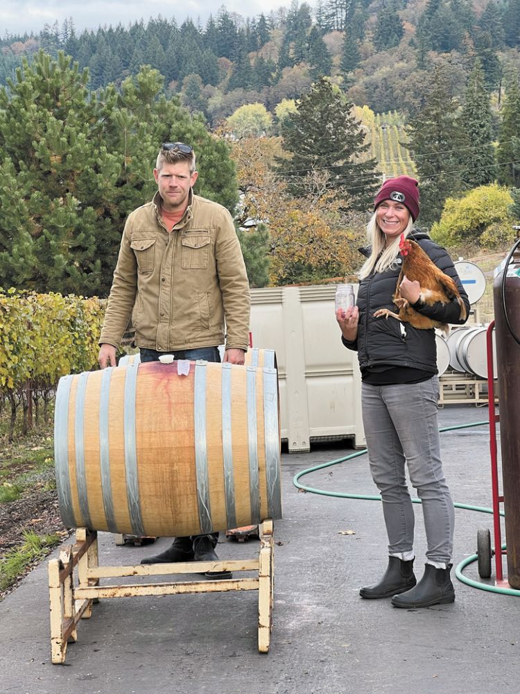 Co-owner and winemaker Bryan Laing with intern Becky Boyd holding Feathers the chicken. ##Photo by Sarah Murdoch