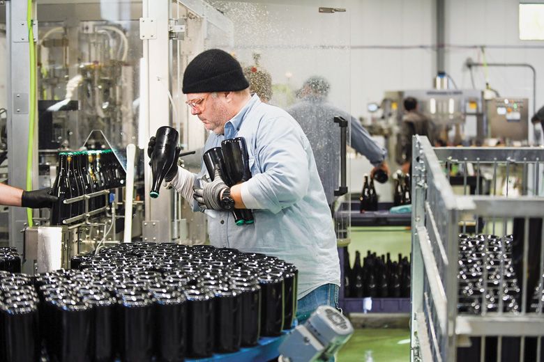 Wine bottles are unloaded from a riddling cage into the chillIng table that freezes the upper neck before the beginning the disgorging process. Wine bottles are unloaded from a riddling cage into the chillIng table that freezes the upper neck before the beginning the disgorging process.