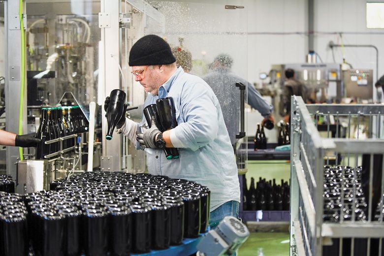 Wine bottles are unloaded from a riddling cage into the chillIng table that freezes the upper neck before the beginning the disgorging process.