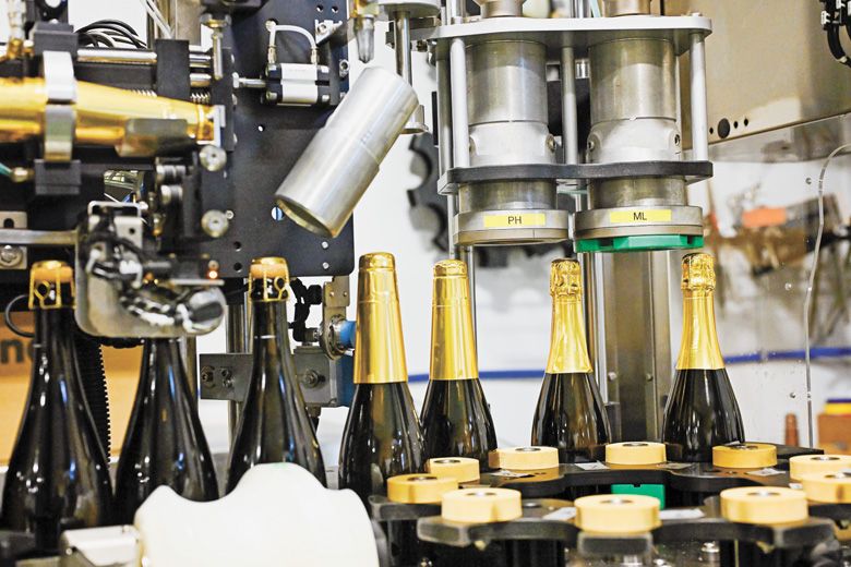 Adding wirehoods and foils are the final steps on the automated bottling line. Adding wirehoods and foils are the final steps on the automated bottling line.